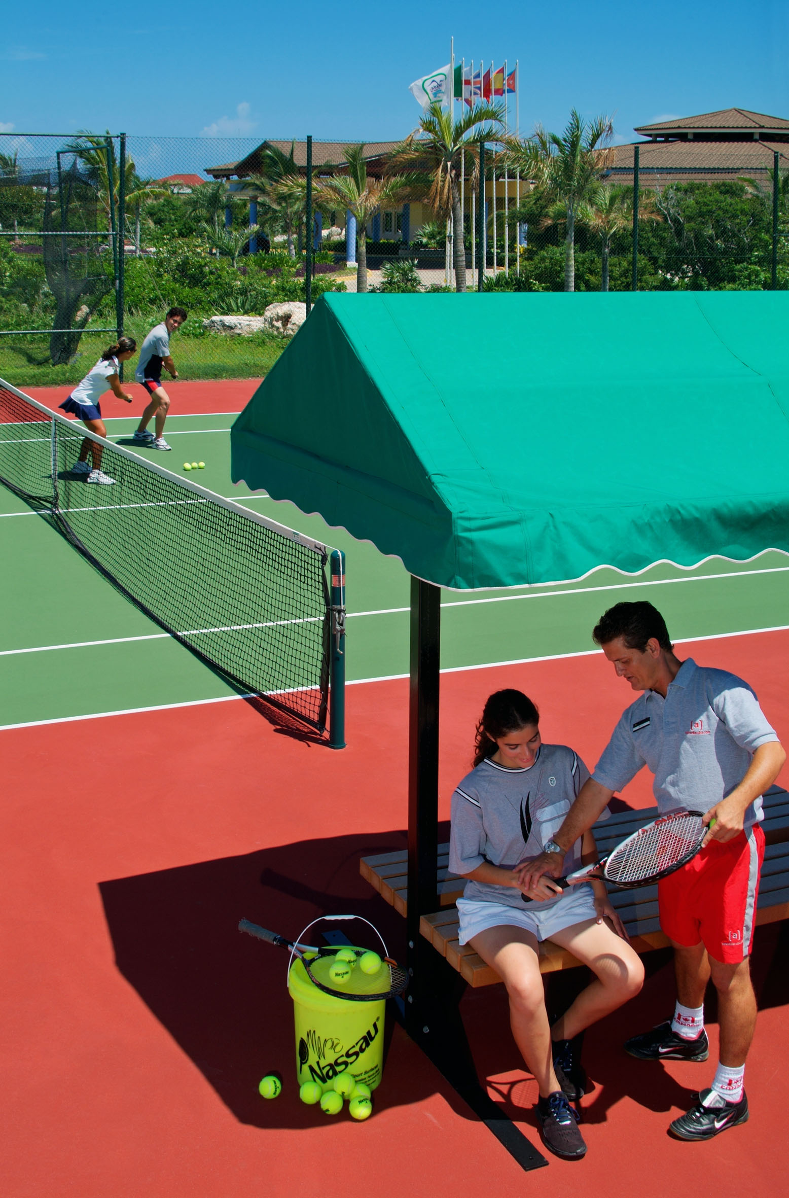 a man and woman sitting on a bench on a tennis court
