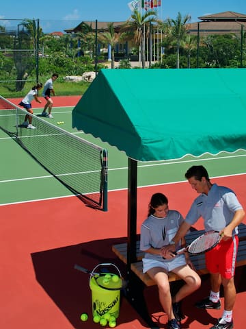 a man and woman sitting on a bench on a tennis court