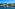 a body of water with boats and houses in the background