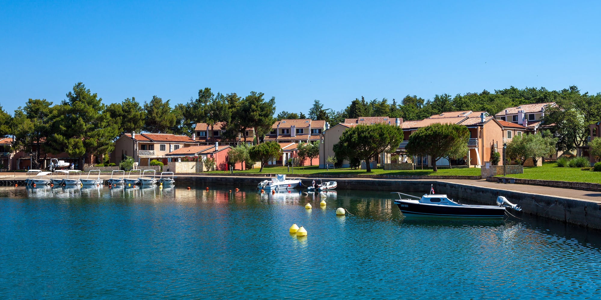a body of water with boats and houses in the background