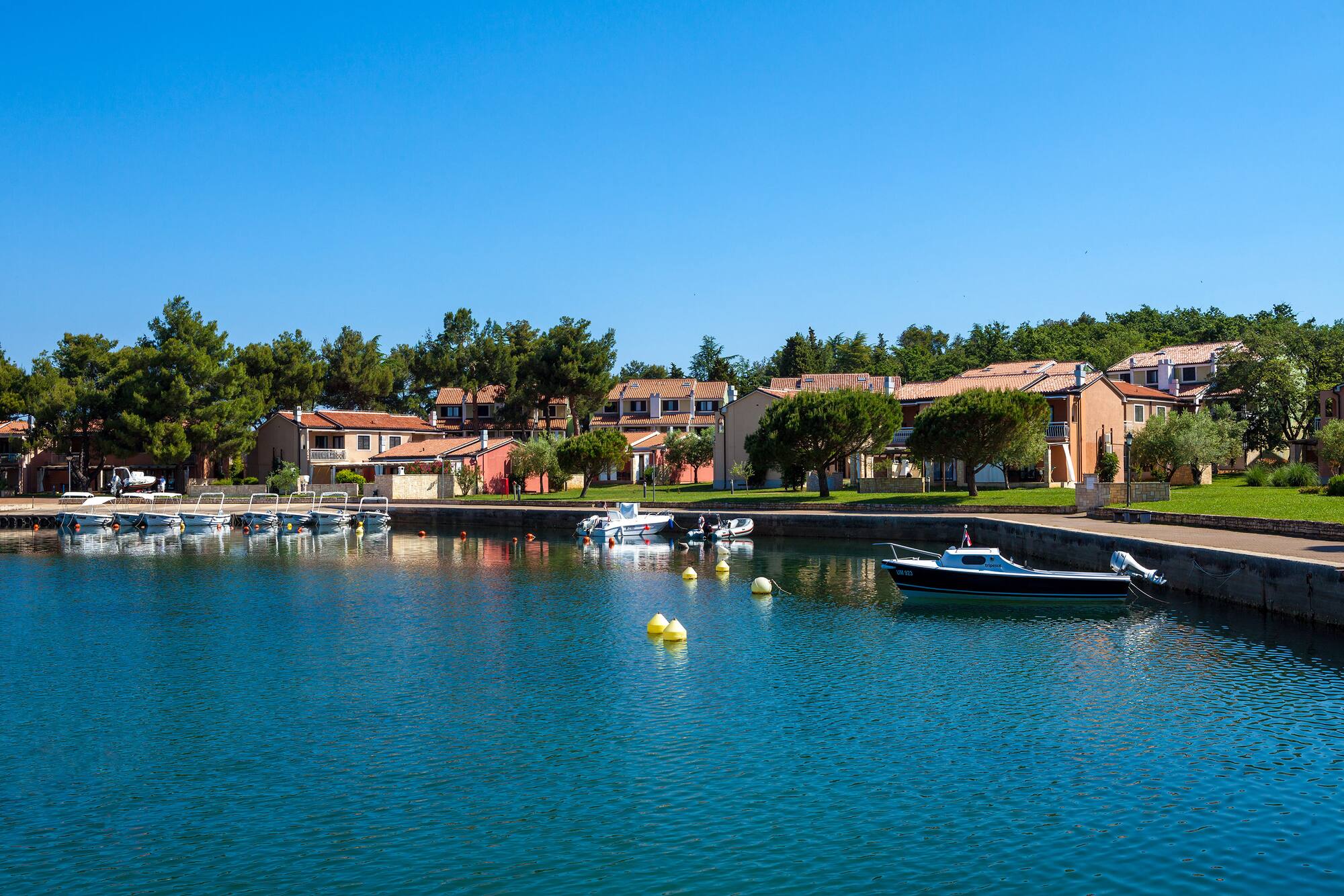 a body of water with boats and houses in the background
