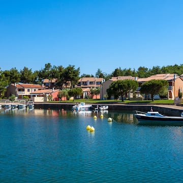 a body of water with boats and houses in the background