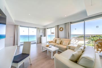 a living room with white furniture and a table