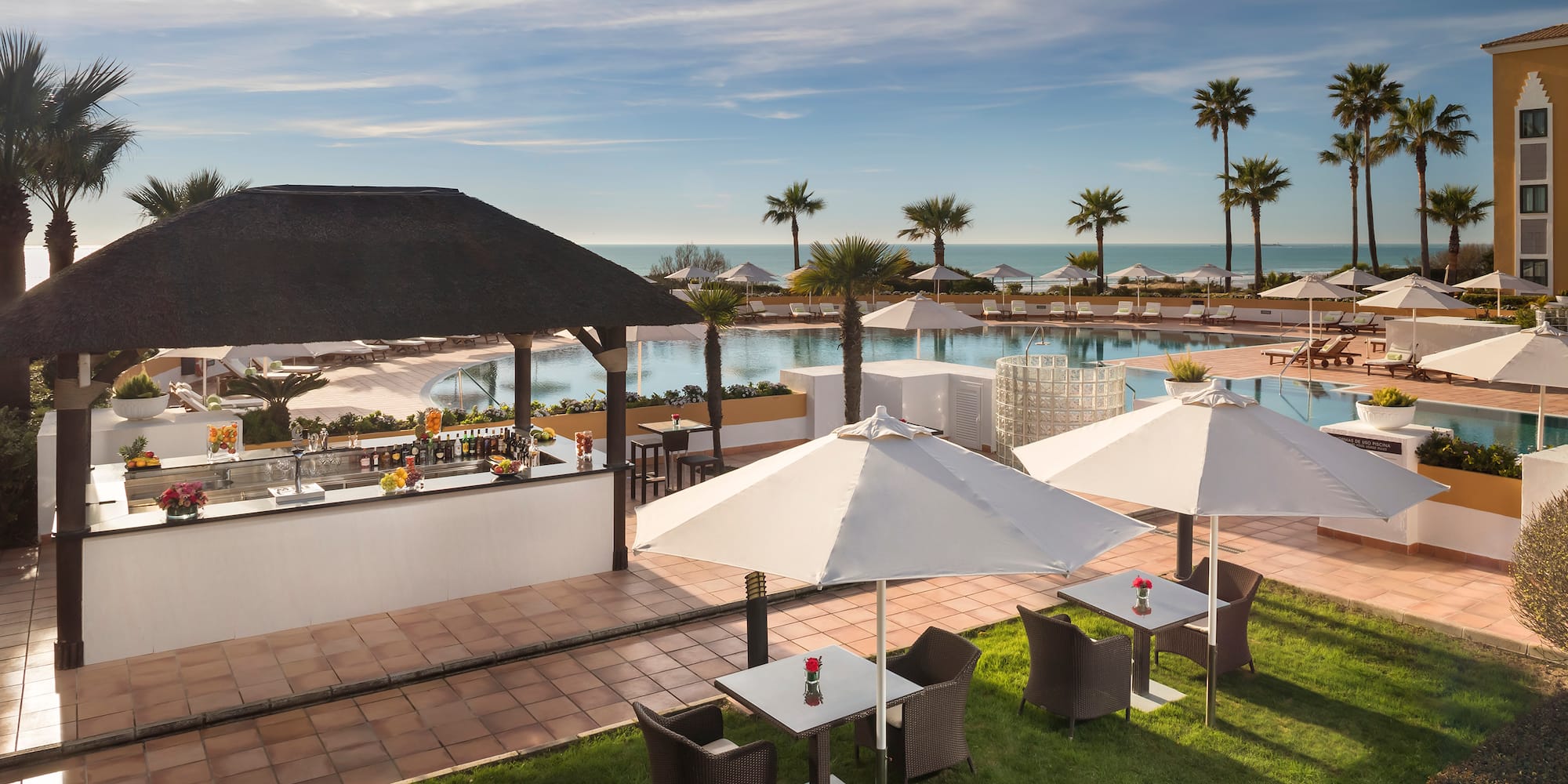 a pool with tables and chairs and umbrellas