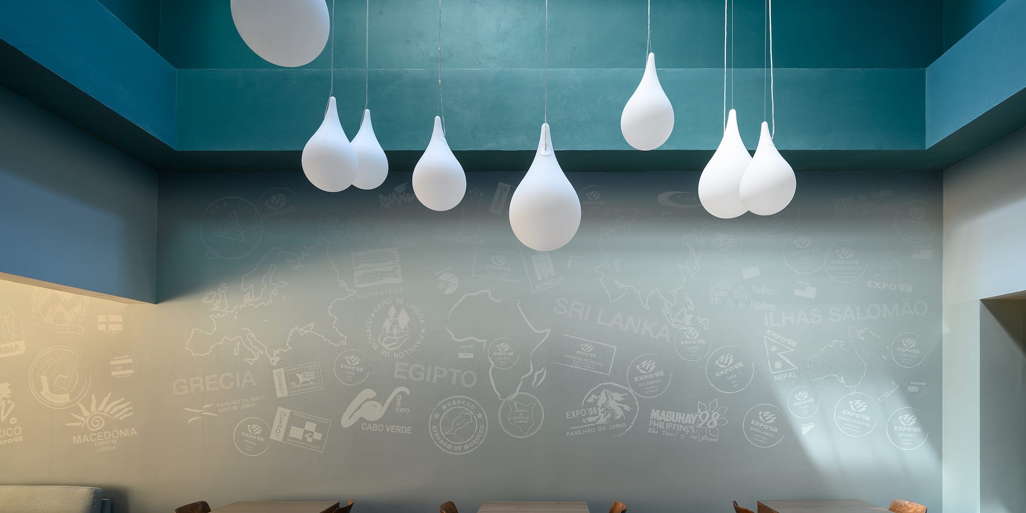 a room with tables and chairs and white balloons