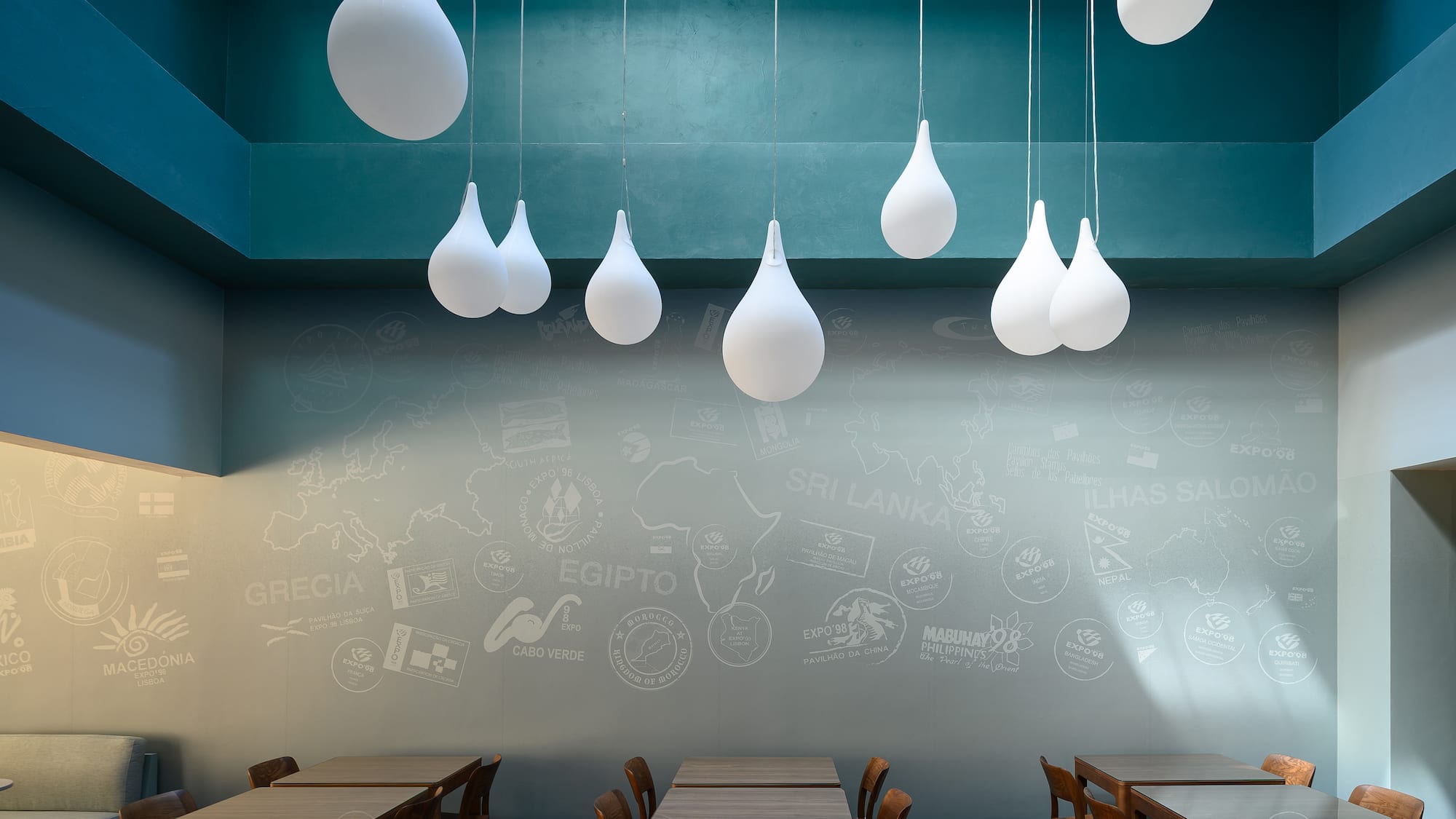 a room with tables and chairs and white balloons