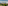 Mediterranean village resort with golf course and mountains under blue sky.