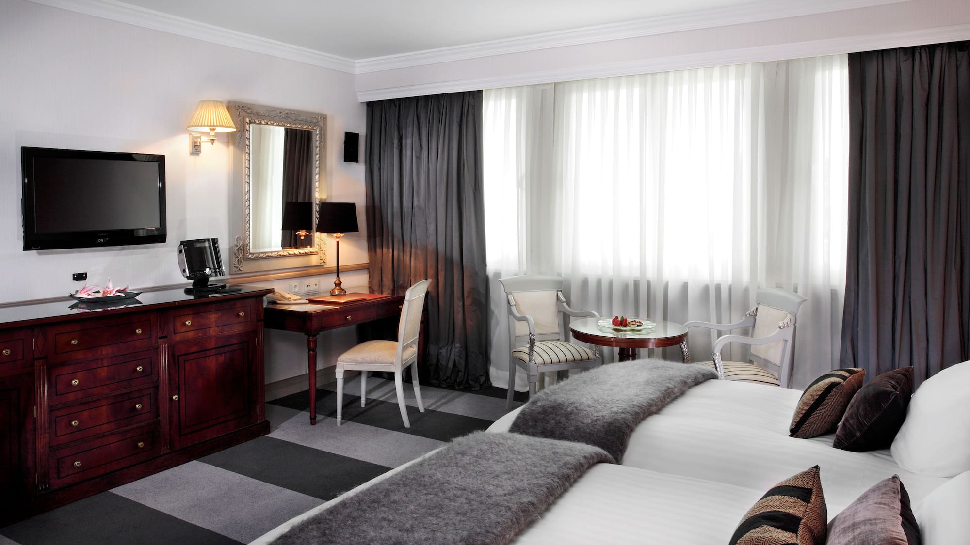 a room with two beds and a desk