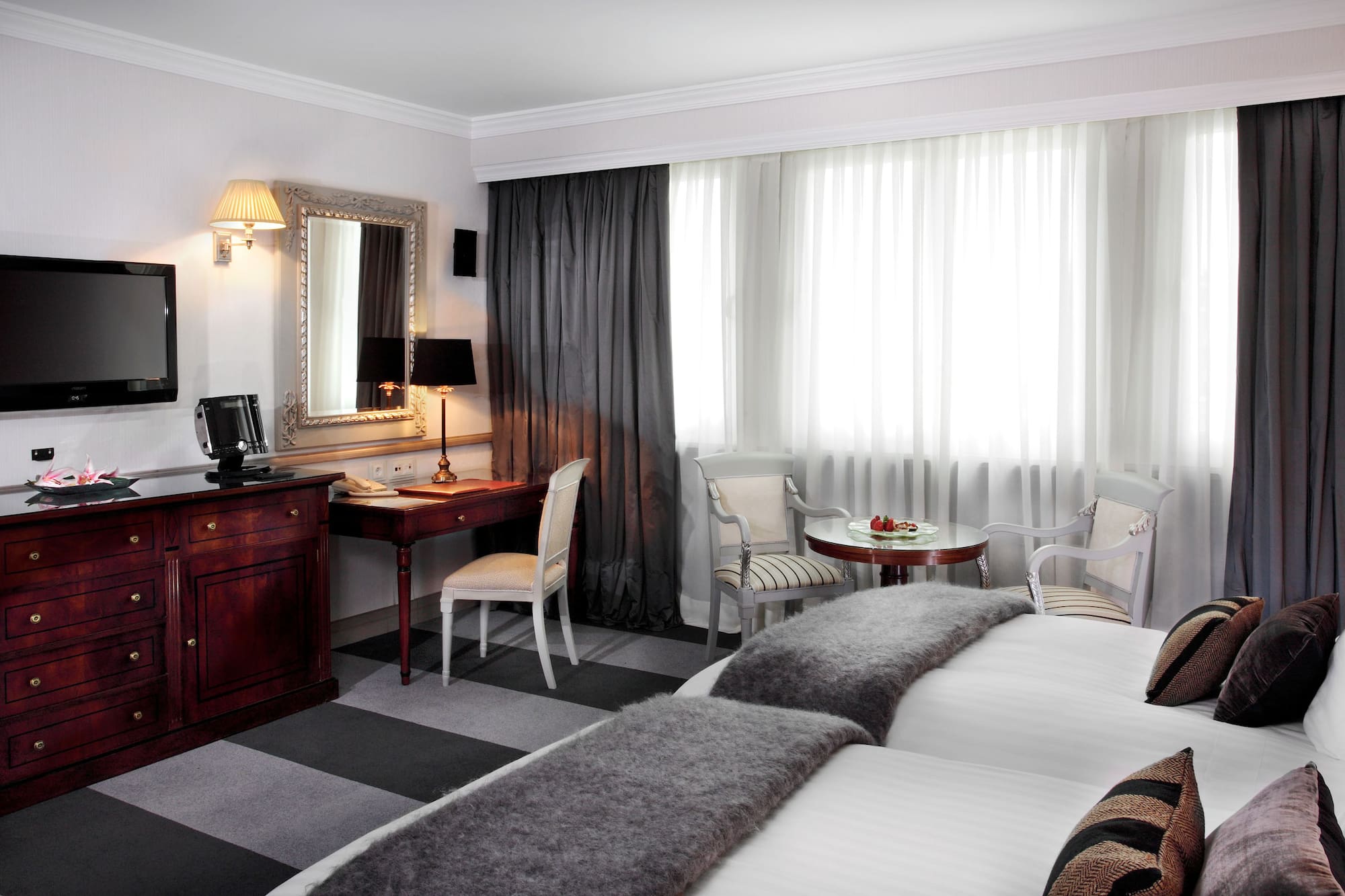 a room with two beds and a desk