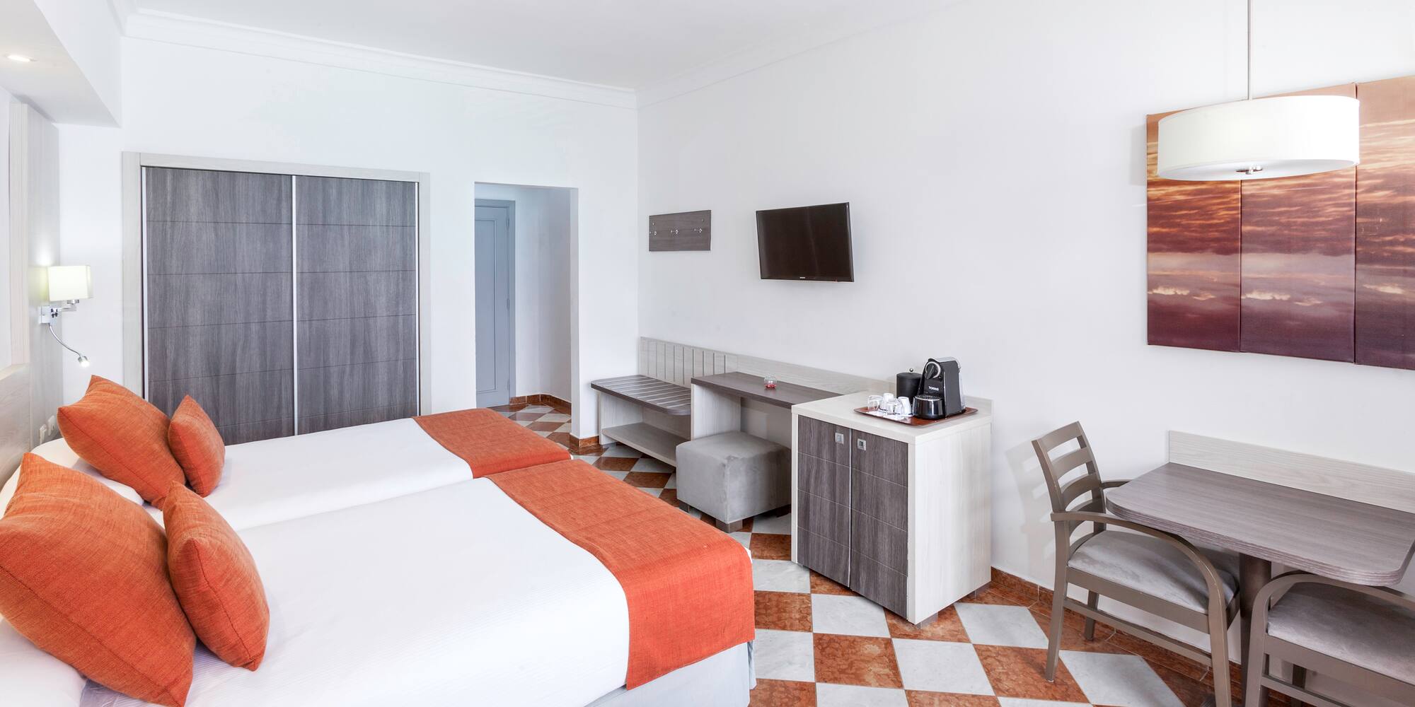 a room with two beds and a table and chairs