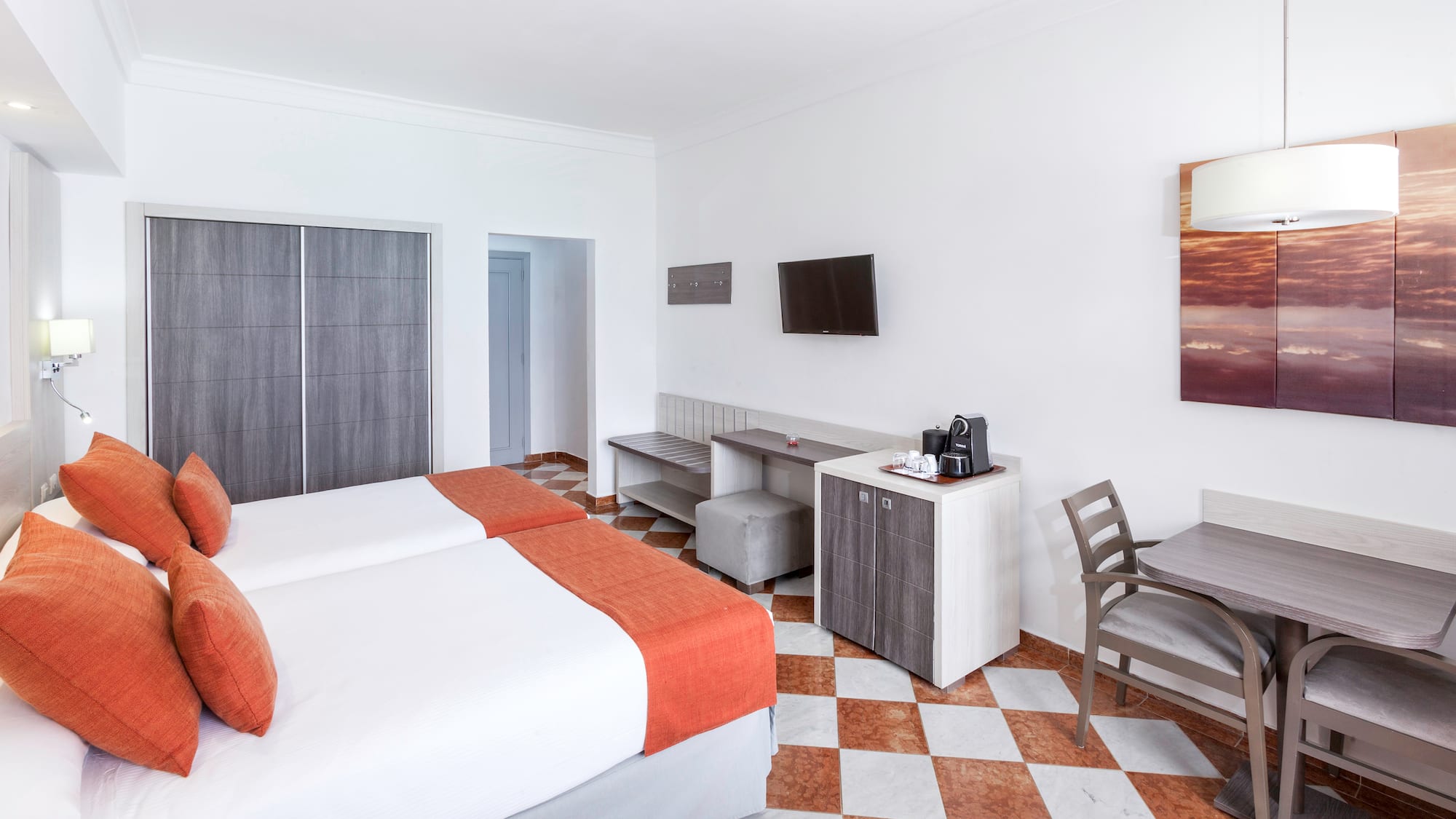 a room with two beds and a table and chairs