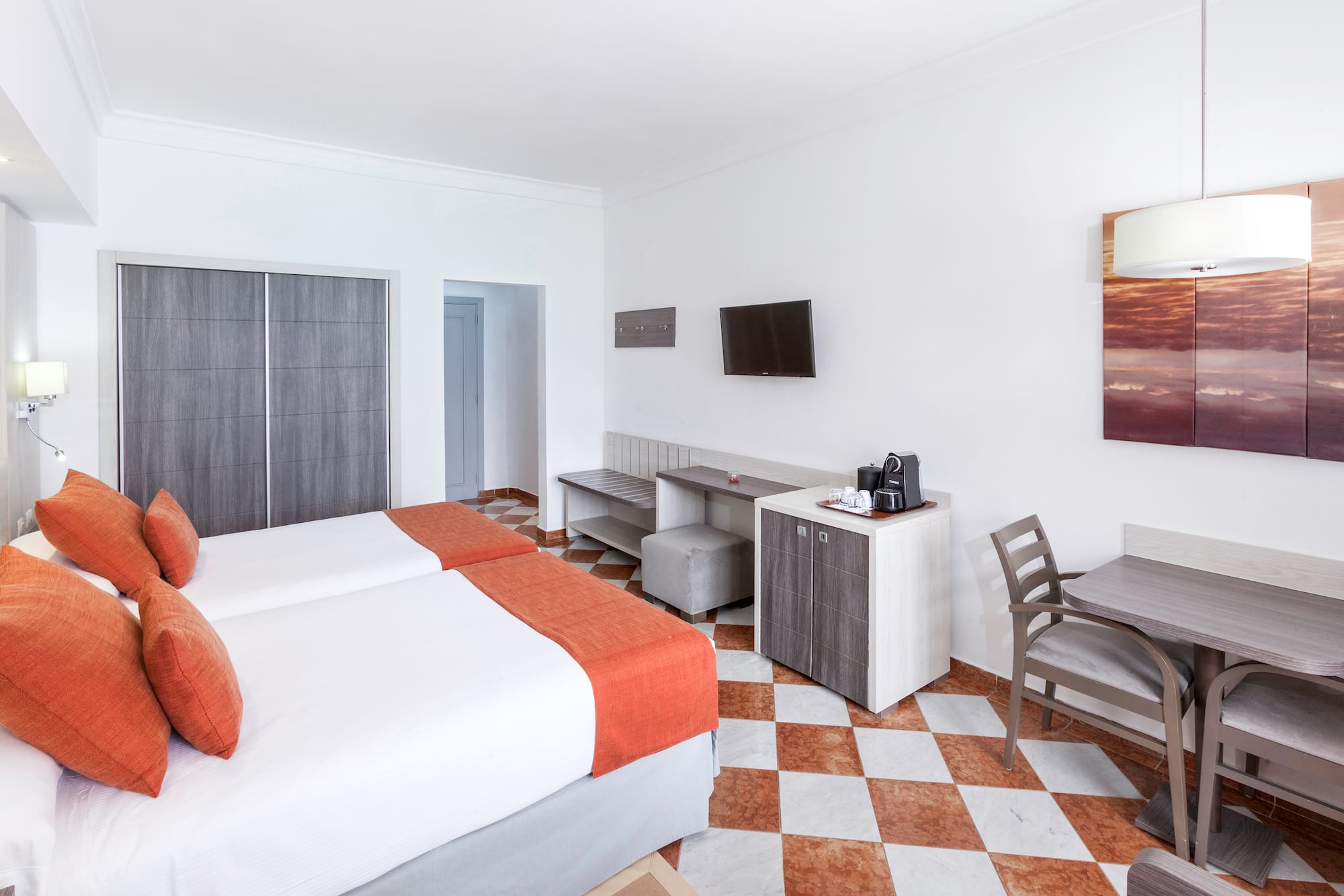 a room with two beds and a table and chairs