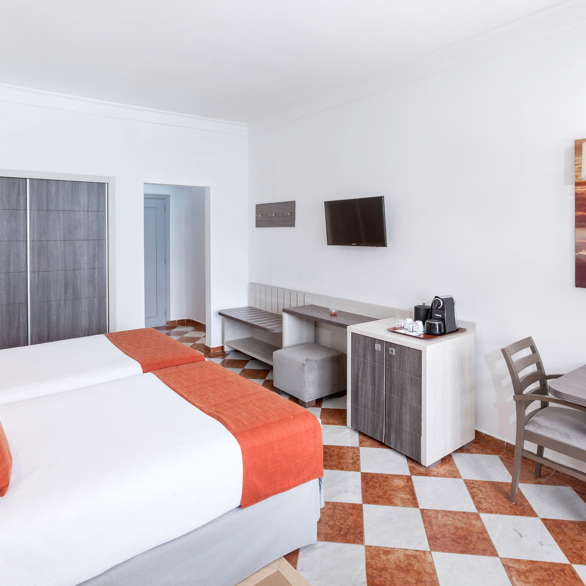 a room with two beds and a table and chairs