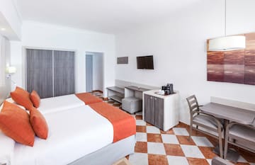 a room with two beds and a table and chairs