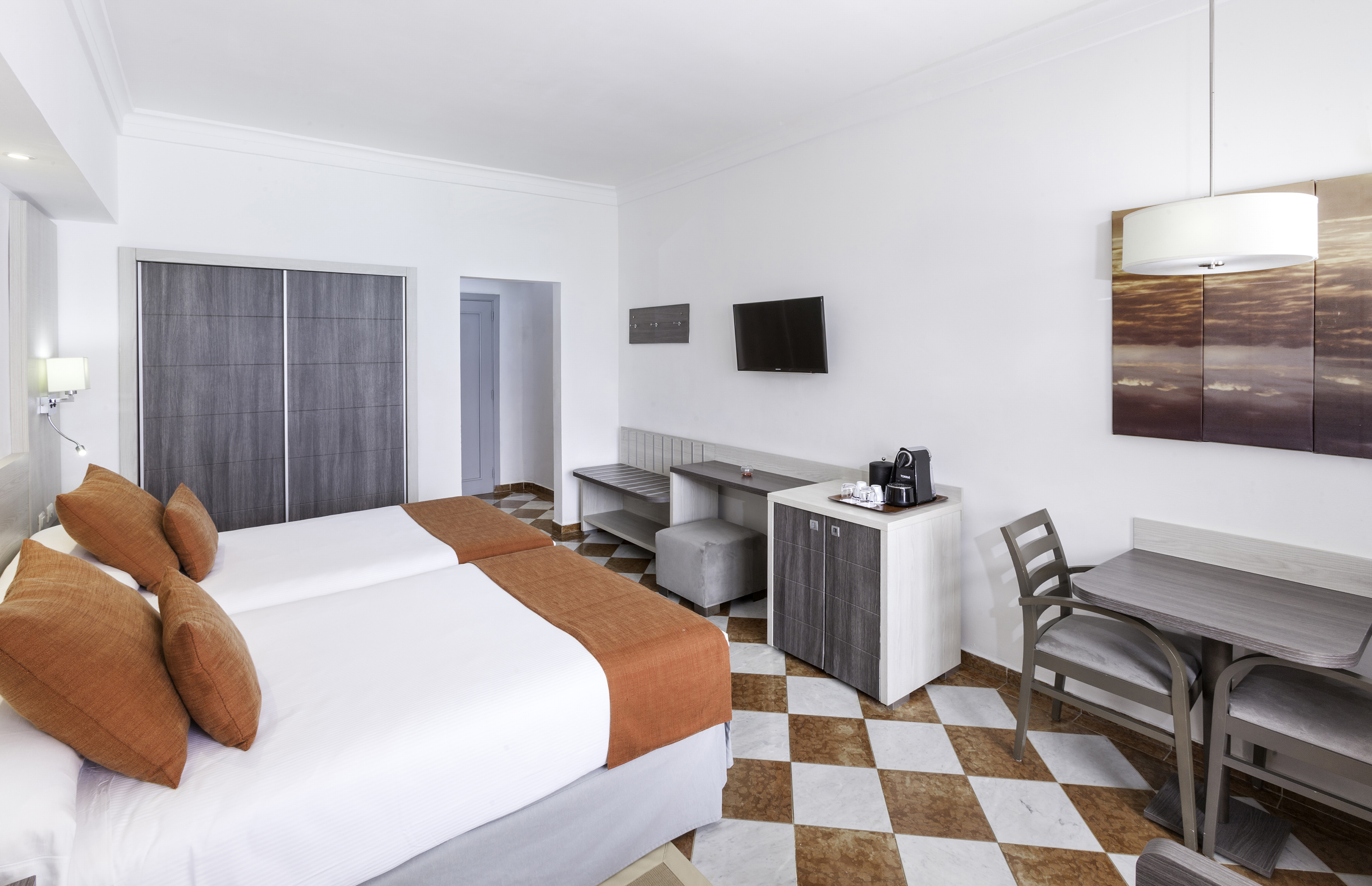 a room with two beds and a table and chairs