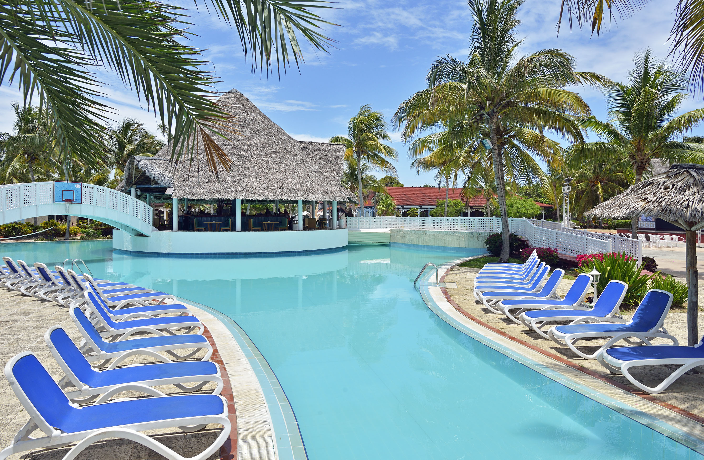 a pool with lounge chairs and a bar