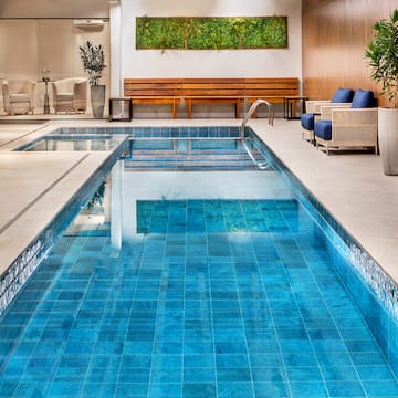a indoor pool with a bench and chairs