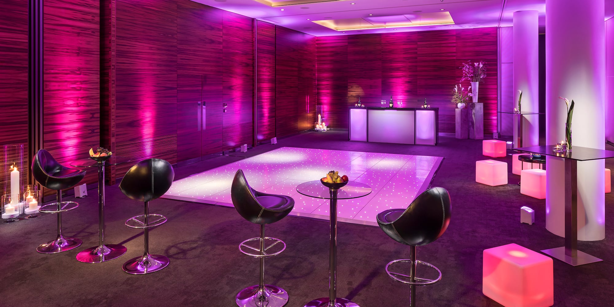 a room with purple lights and chairs