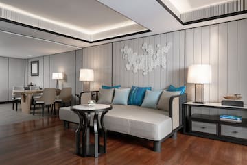 a room with a couch and table and lamps