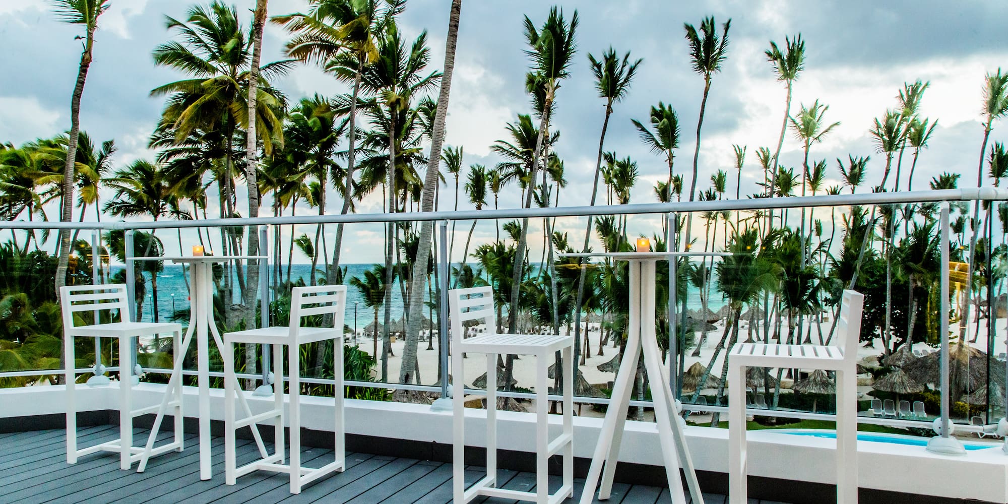a white table and chairs on a deck overlooking a beach