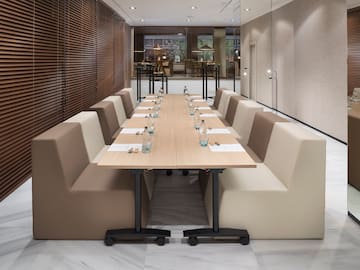 a long table with white chairs and a brown table