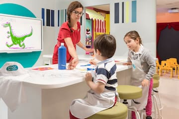 a woman and children painting