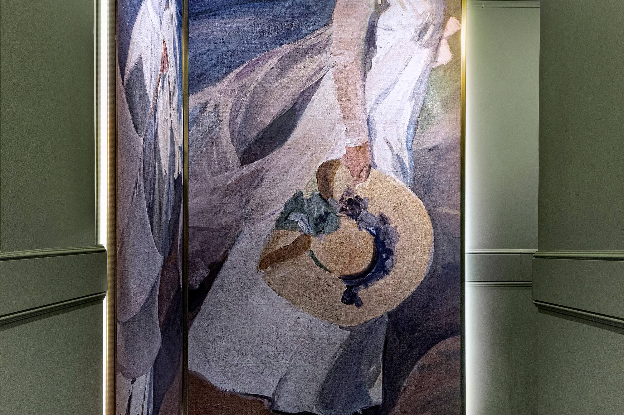 Modern hotel corridor with large art of a woman holding a hat, LED lighting.