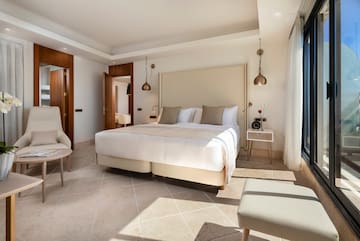 a bedroom with a bed and chairs