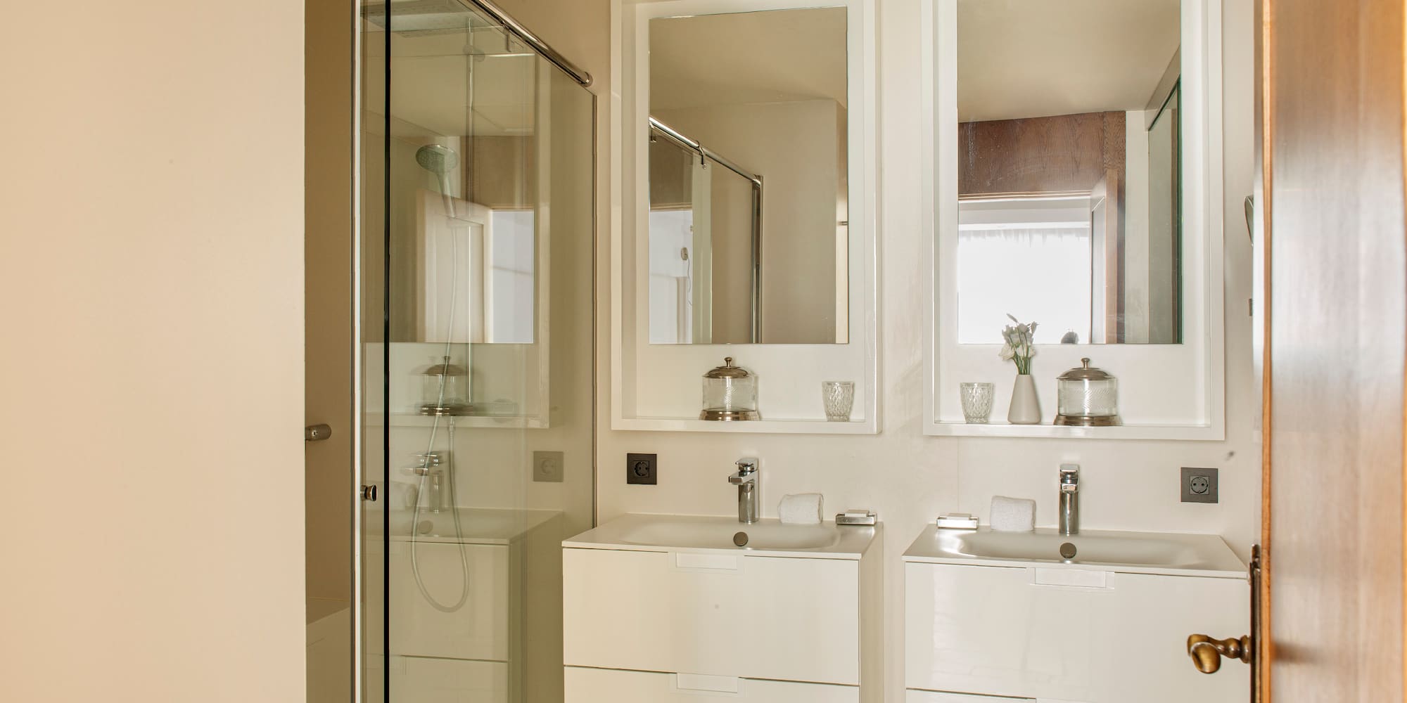 a bathroom with white cabinets and mirrors