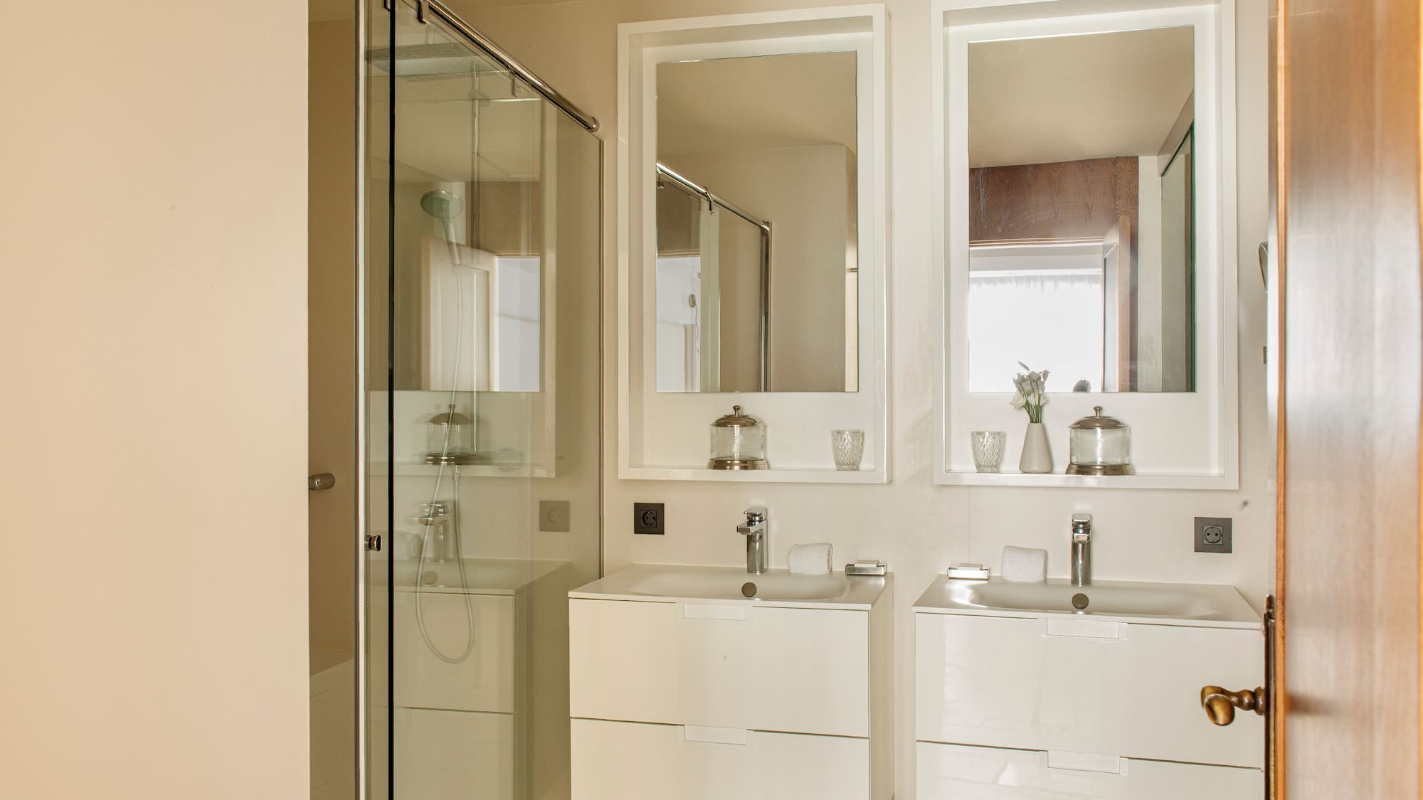 a bathroom with white cabinets and mirrors
