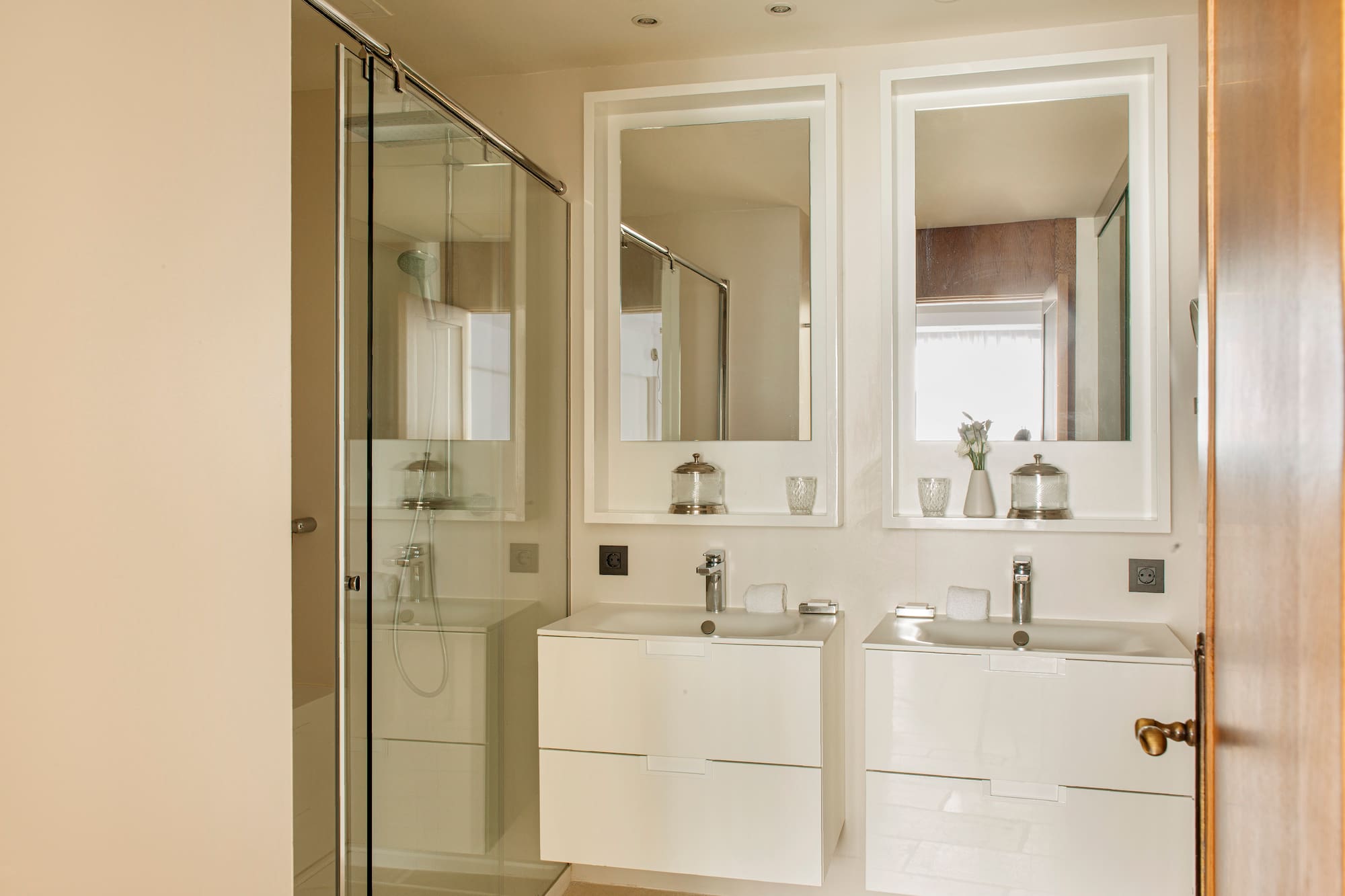 a bathroom with white cabinets and mirrors