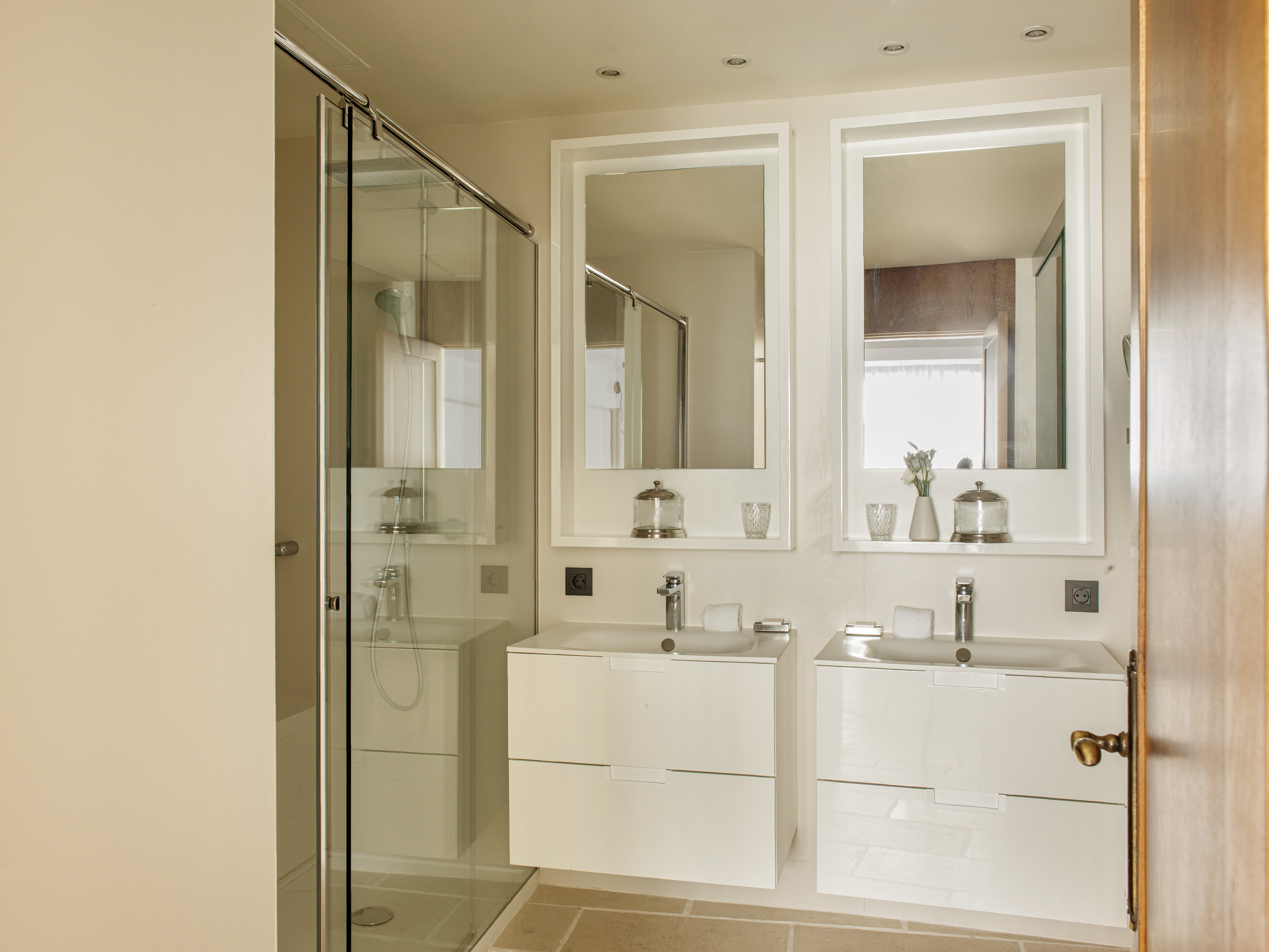 a bathroom with white cabinets and mirrors