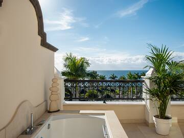 a bathtub on a balcony overlooking the ocean