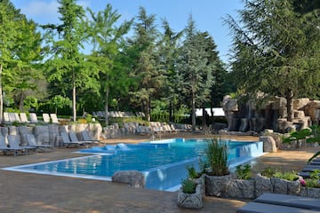 a pool with chairs and trees
