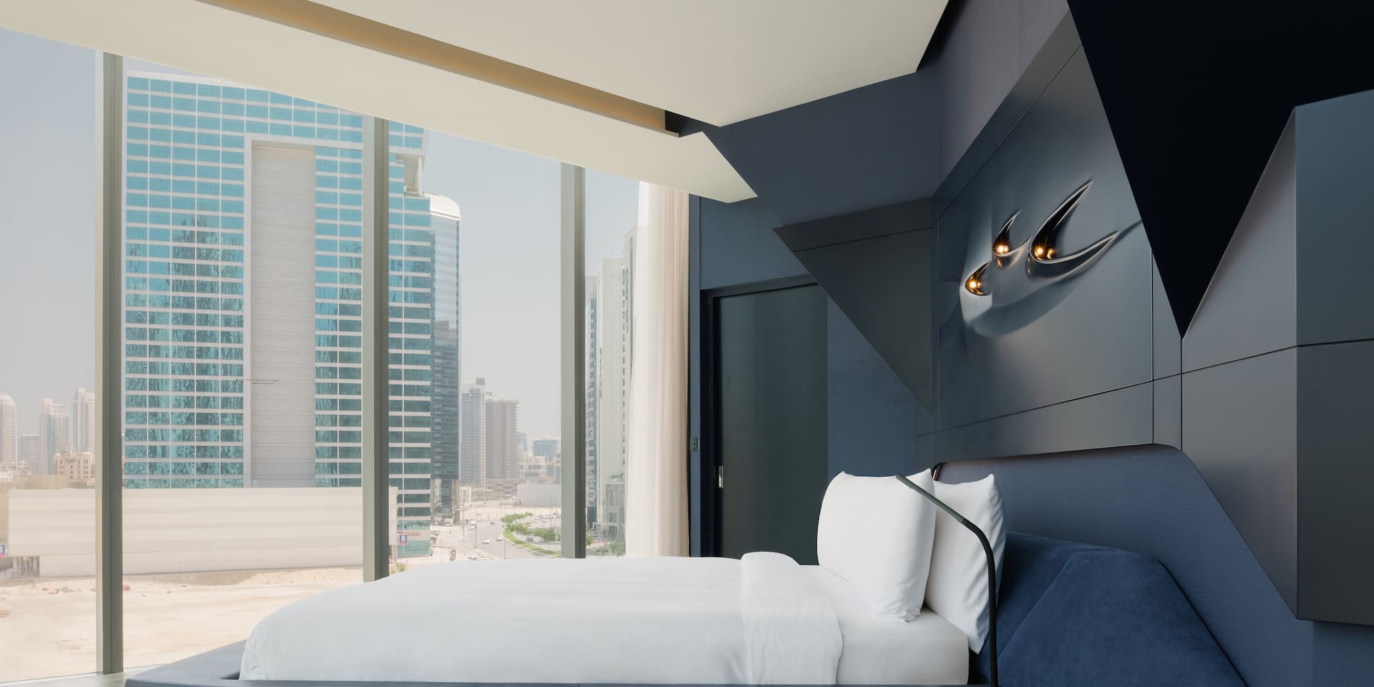 a bed in a room with a window and city view