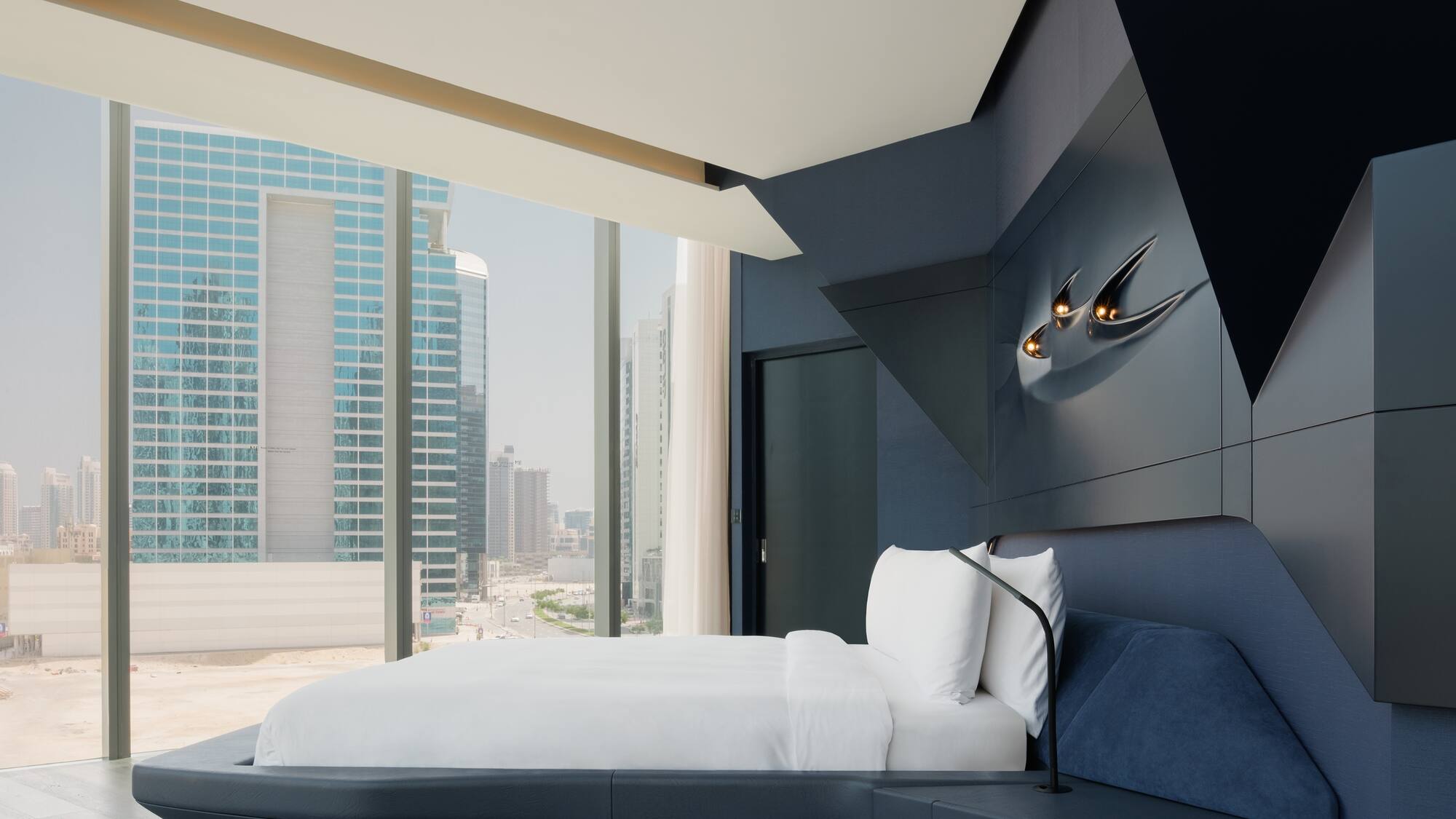 a bed in a room with a window and city view