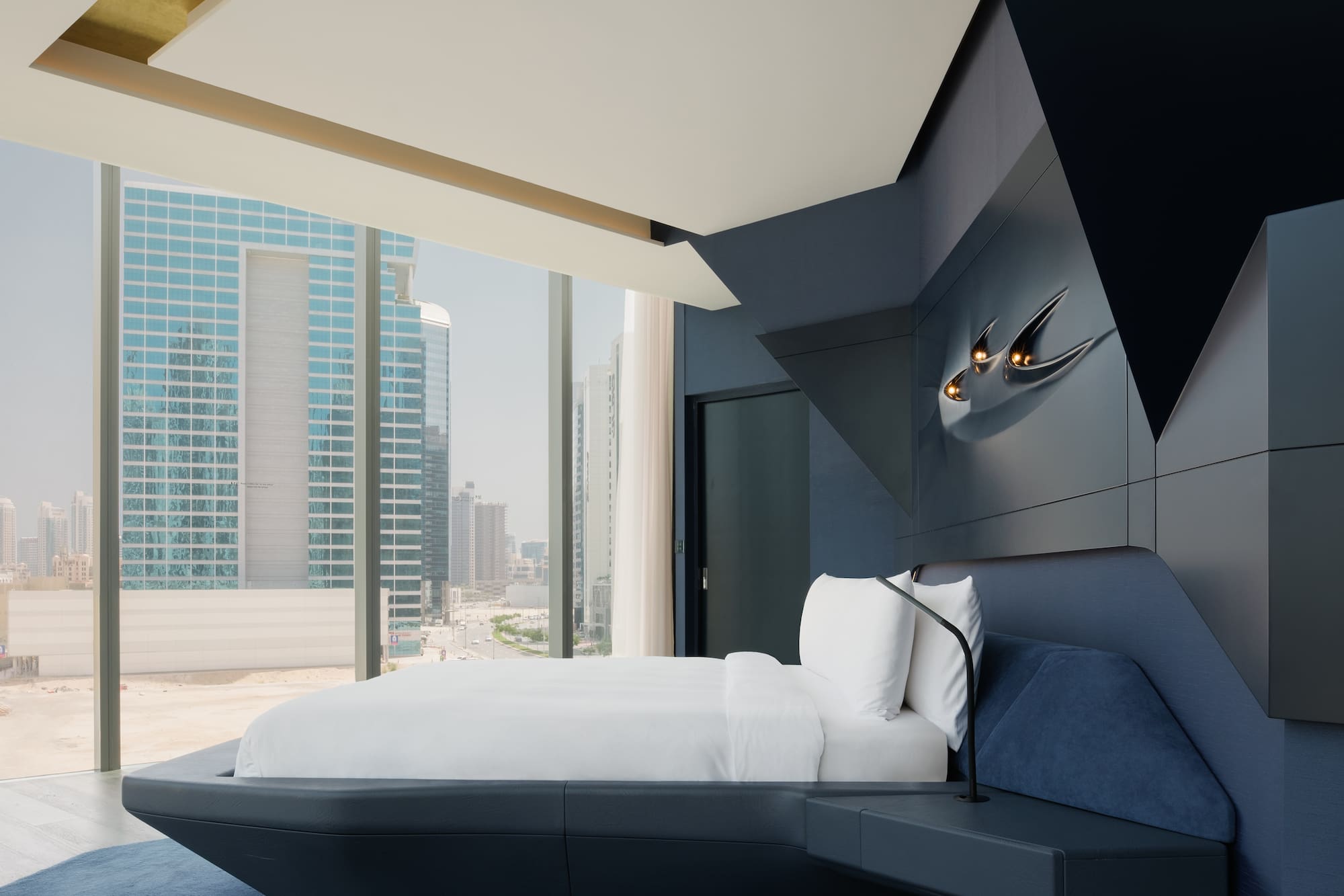 a bed in a room with a window and city view