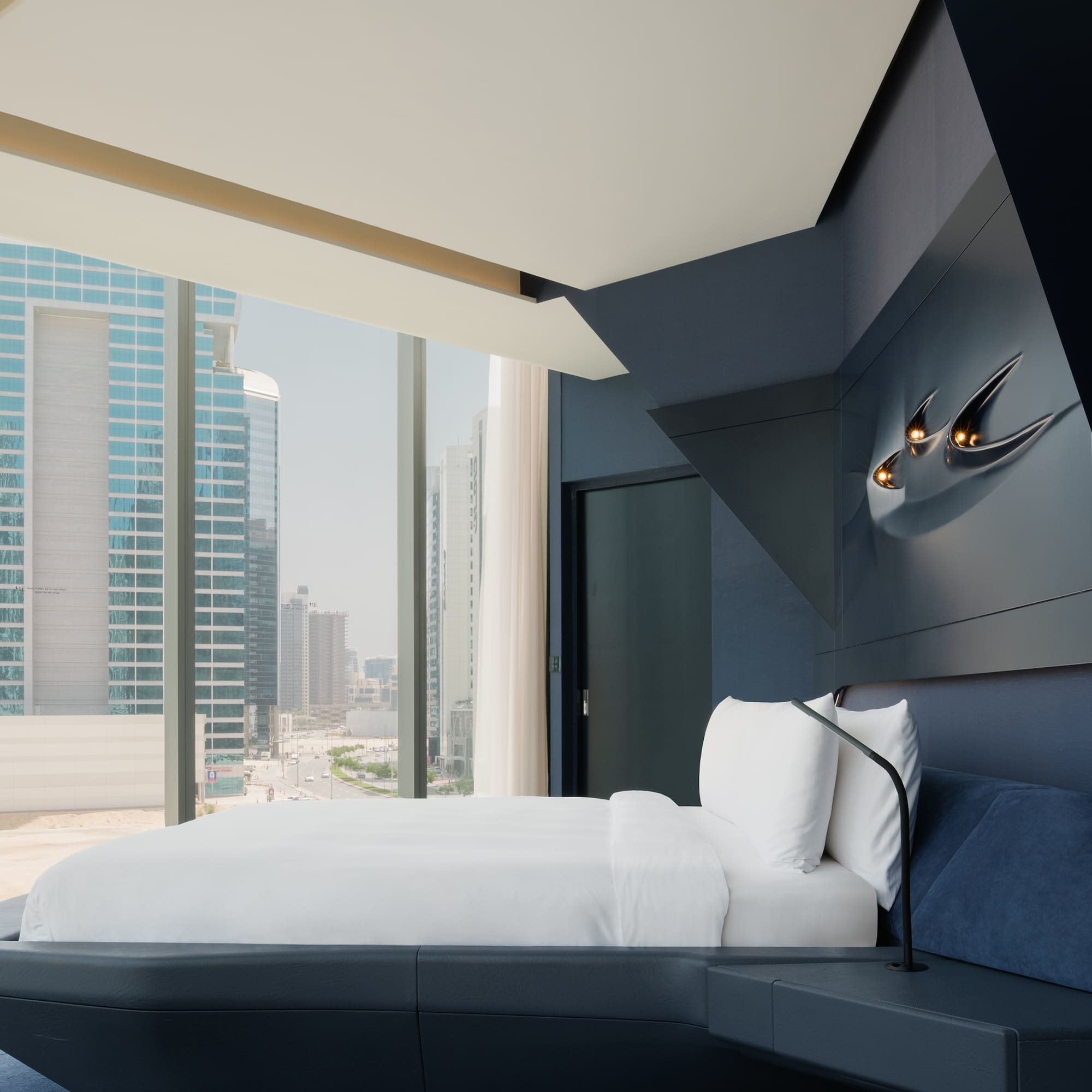 a bed in a room with a window and city view