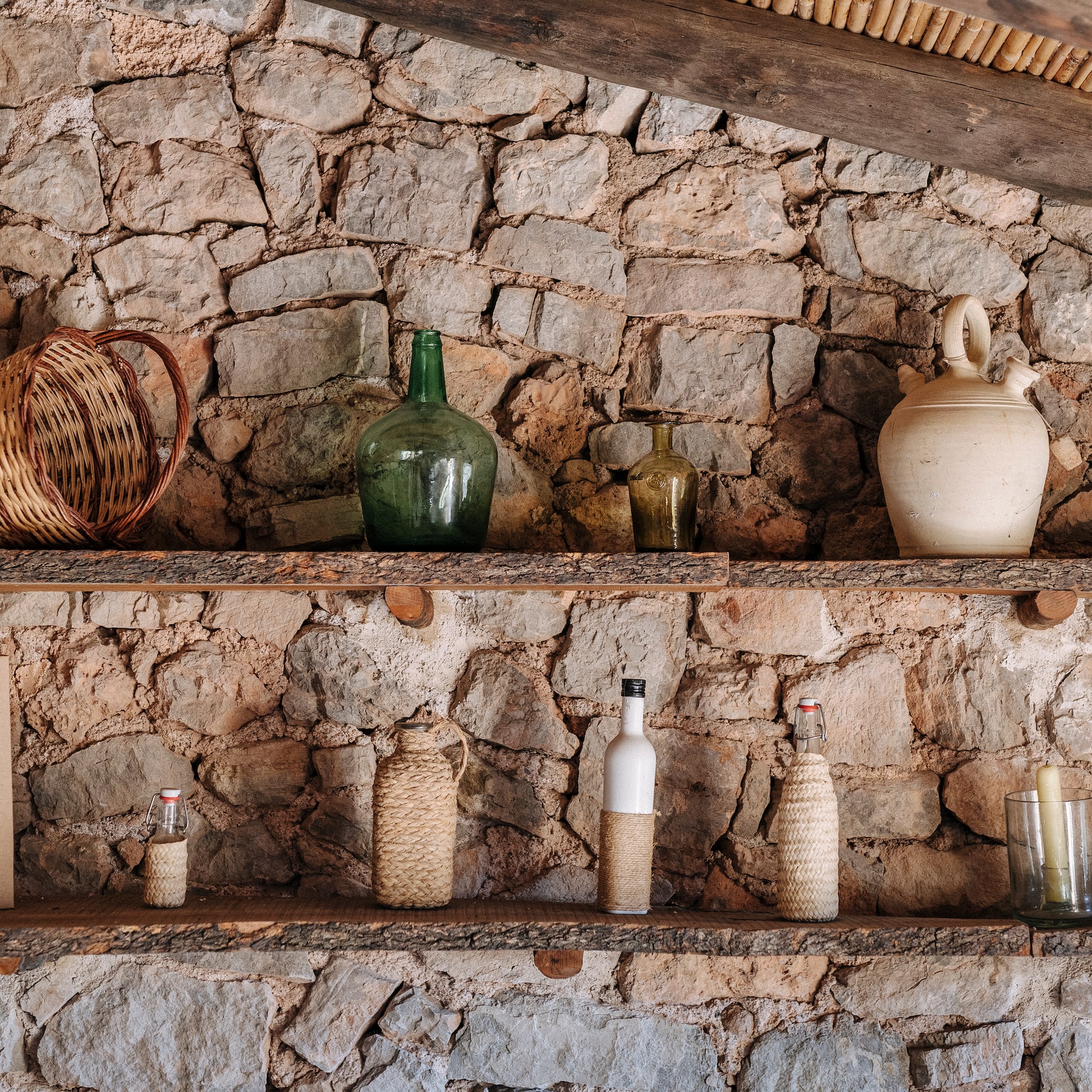 a shelf with bottles and candles on it