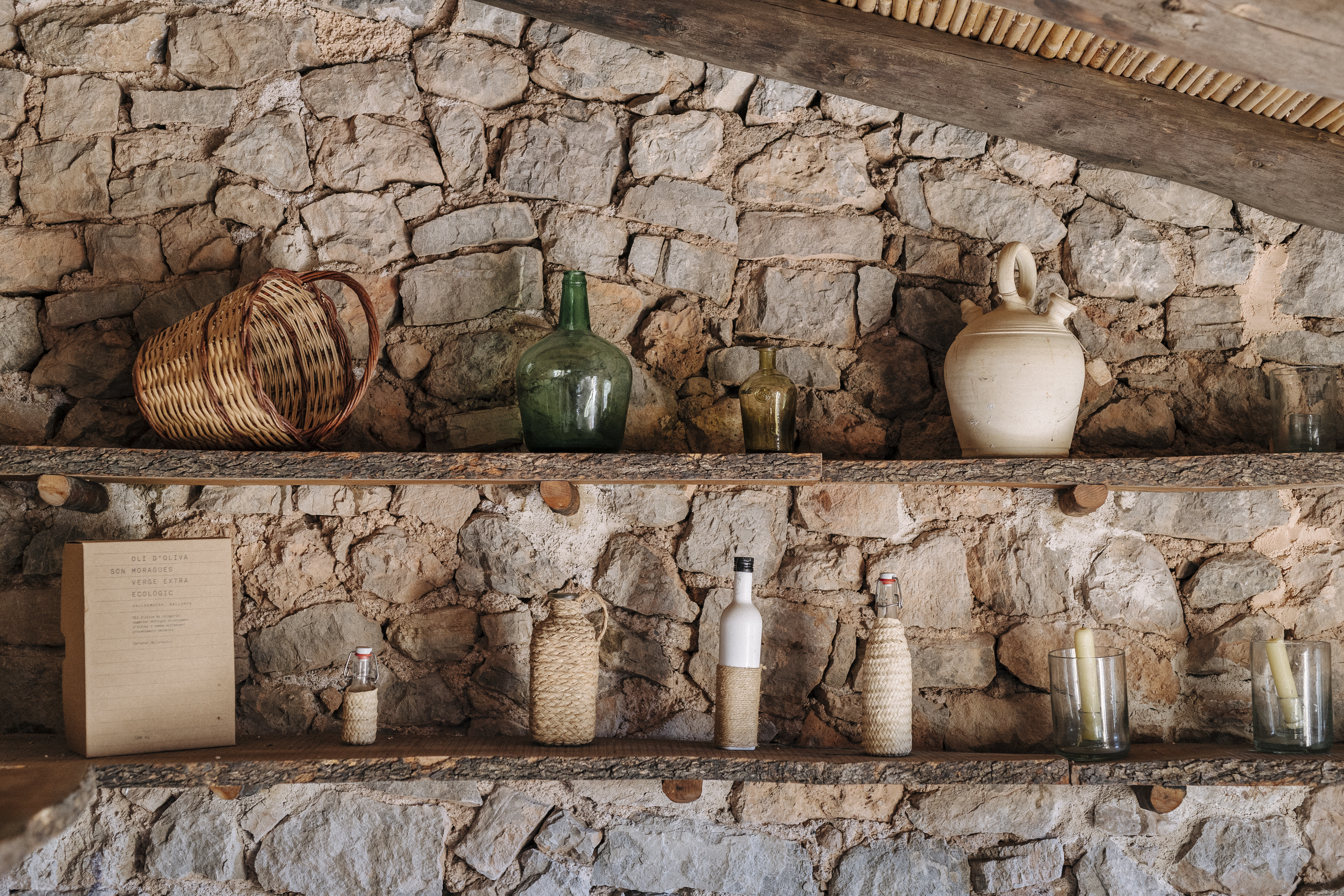 a shelf with bottles and candles on it