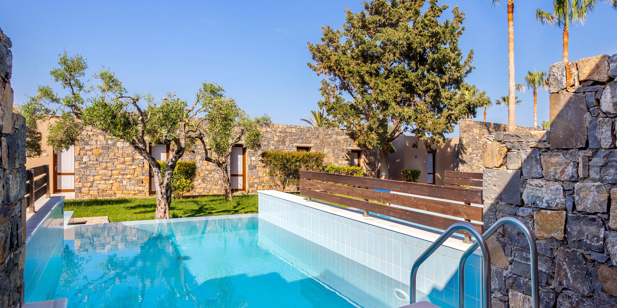 a pool with trees and a stone wall