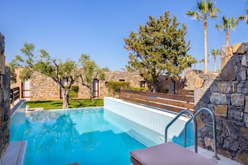 a pool with trees and a stone wall