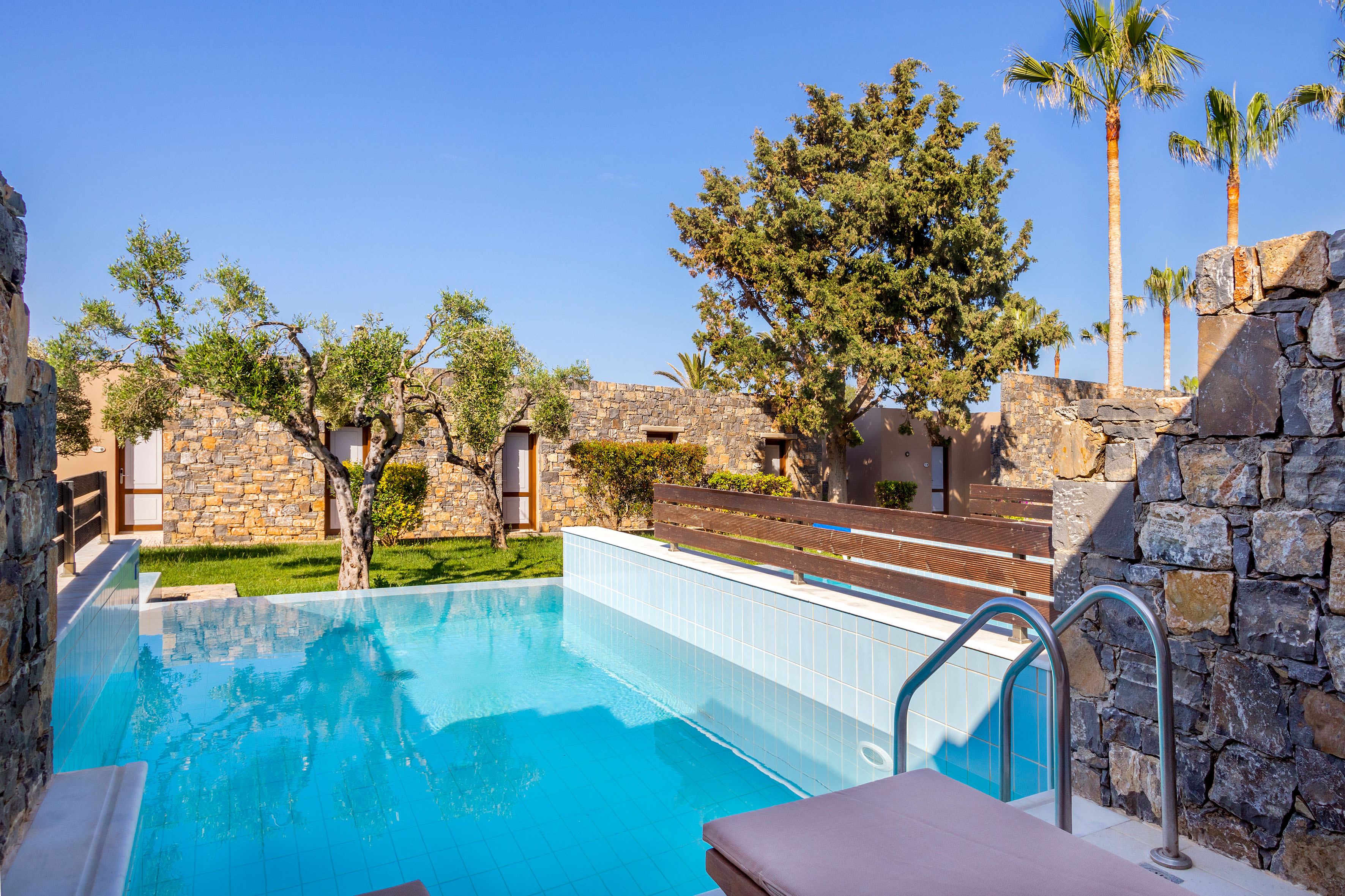 a pool with trees and a stone wall