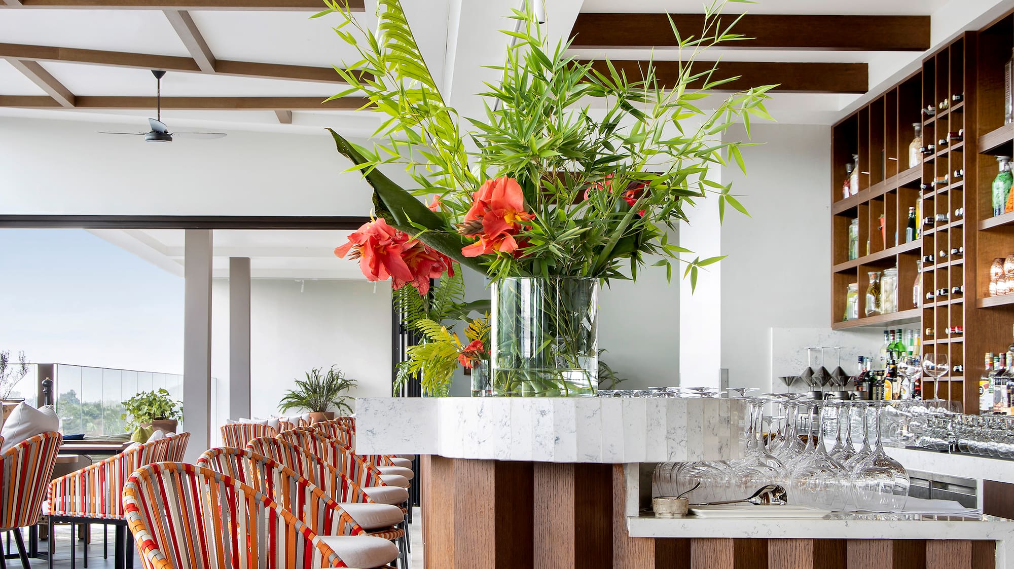 a bar with chairs and a vase of flowers