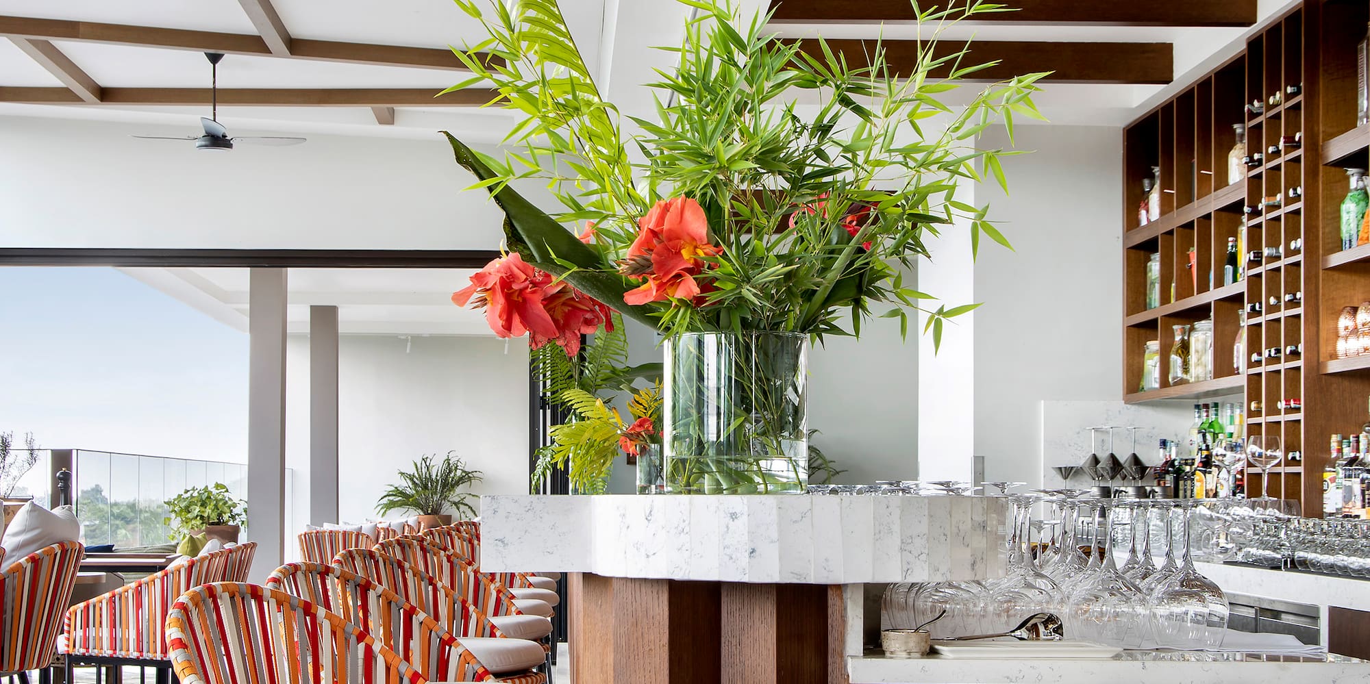a bar with chairs and a vase of flowers