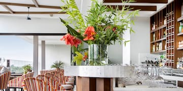 a bar with chairs and a vase of flowers
