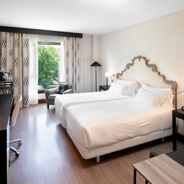 a room with two beds and a desk