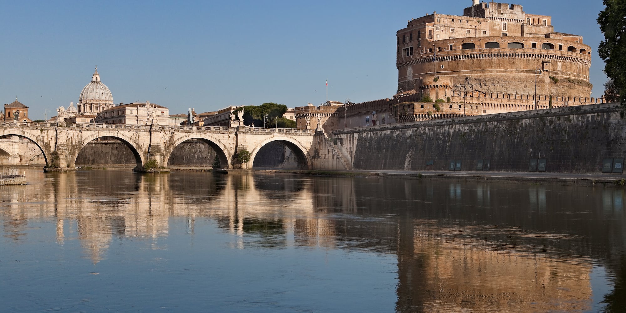 a bridge over a body of water with a castle in the background