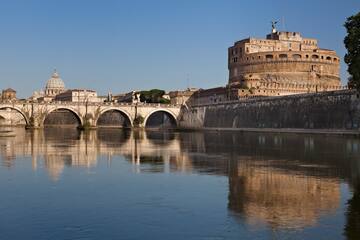 a bridge over a body of water with a castle in the background