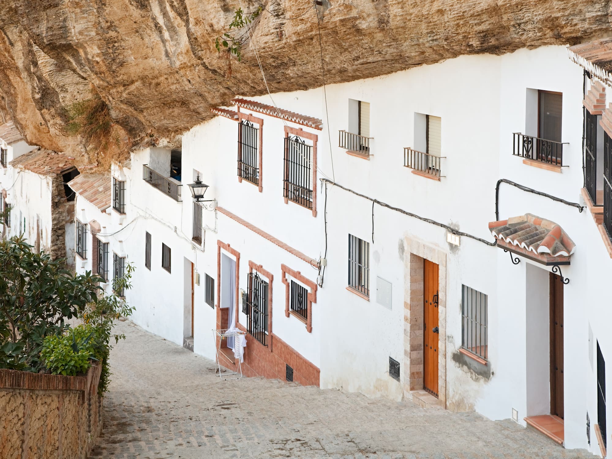 Whitewashed cave houses built into rock in Setenil de las Bodegas, Andalusia.